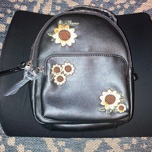 Black mini backpack with sunflowers.
